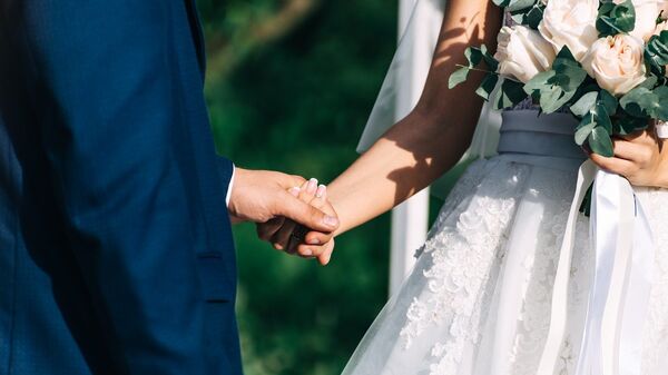 Жених и невеста во время свадебной церемонии держатся за руки - Sputnik Грузия