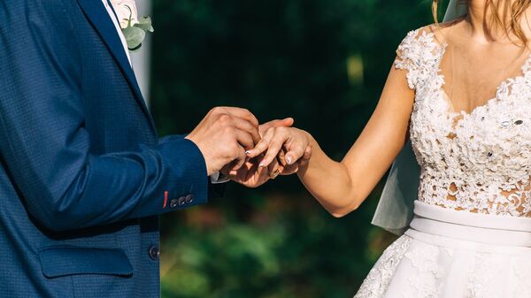 Жених и невеста во время свадебной церемонии. Невесте одевают на палец обручальное кольцо - Sputnik Грузия