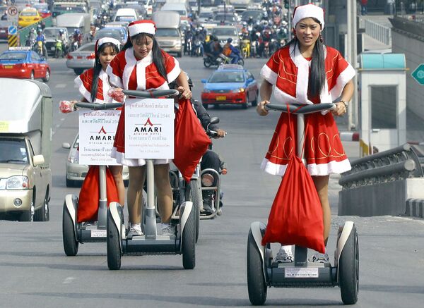 Работницы отеля в костюмах Санта-Клауса во время раздачи подарков в Бангкоке  - Sputnik Грузия