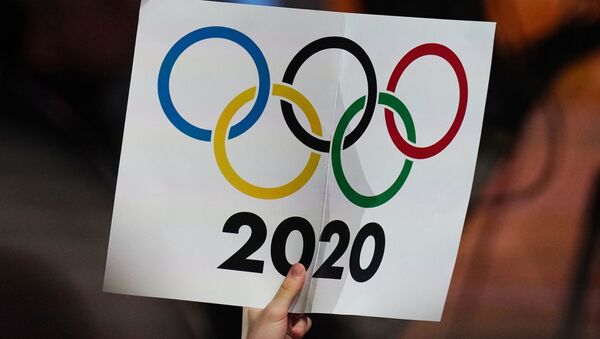 Журналист держит плакат с олимпийскими кольцами - Sputnik Грузия