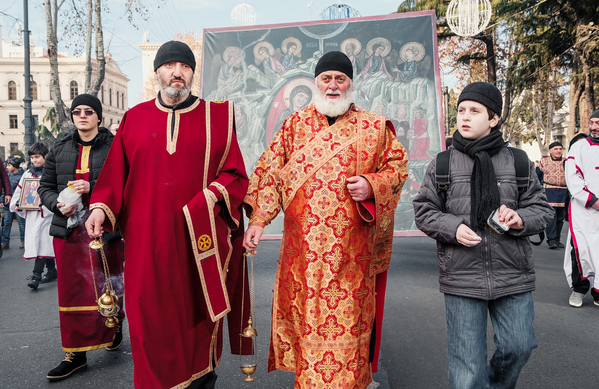 Во главе процессии идут представители духовенства. Часть участников шествия несут через весь город огромную икону Рождения Христа  - Sputnik Грузия