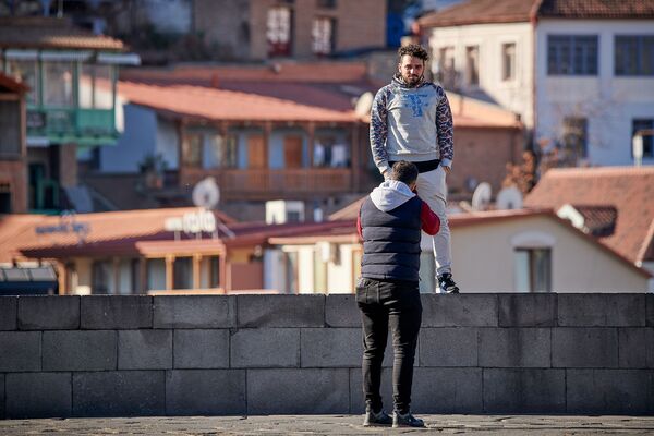 Немало людей при этом залезает на парапет смотровой площадки у памятника Вахтангу Горгасали ради красивого снимка - Sputnik Грузия