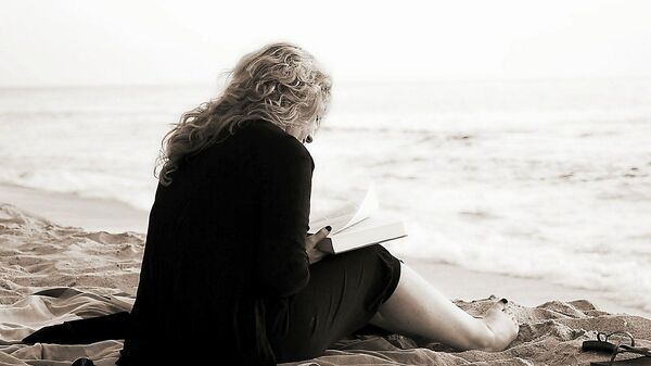 ქალი ზღვის ნაპირზე კითხულობს წიგნს - Sputnik საქართველო