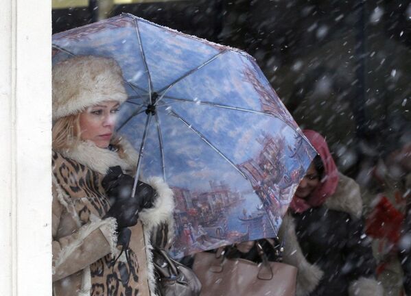 Девушка пережидает снегопад возле подземного пешеходного перехода на Тверской улице в Москве - Sputnik Грузия