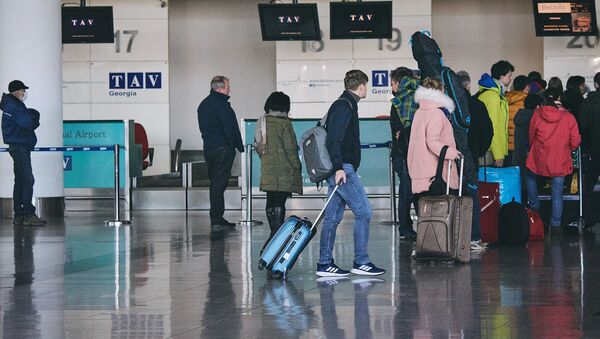 Туристы с чемоданами перед отлетом на стойке регистрации в тбилисском аэропорту - Sputnik Грузия