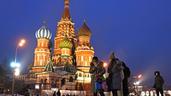 Иностранные туристы в защитных масках на фоне Храма Василия Блаженного на Красной площади в Москве - Sputnik Грузия