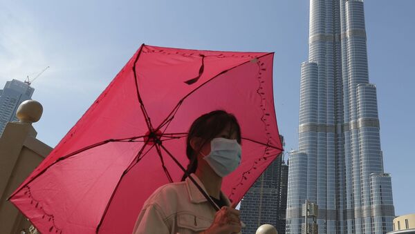 Женщина в маске у башни Бурдж-Халифа в Дубае, ОАЭ - Sputnik Грузия