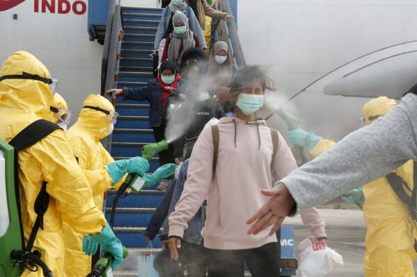 Медики опрыскивают индонезийских граждан антисептиком после прибытия из китайского Уханя, центра эпидемии коронавируса - Sputnik Грузия