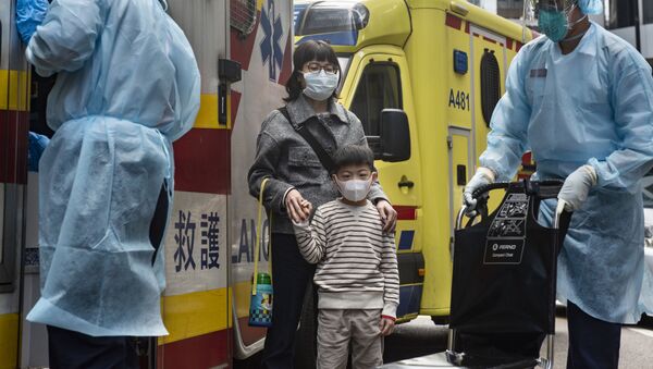Женщина и ребенок в защитных масках рядом с автомобилем скорой помощи - Sputnik Грузия