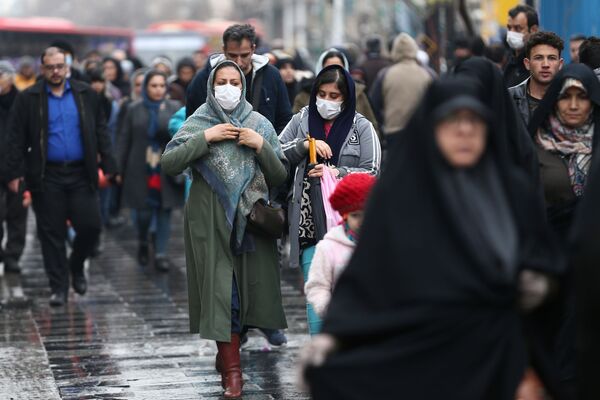 Жители Ирана идут по улице Тегерана в масках, опасаясь коронавируса. Хотя тут пока гораздо меньше случаев, чем к примеру, в Японии - 100 против 160, но медицина не так развита. Поэтому на 100 заболевших пришлось 16 погибших - Sputnik Грузия
