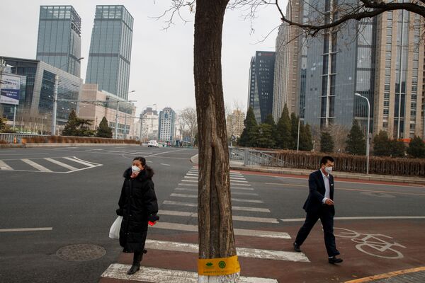 Тем временем улицы китайских городов, обычно переполненные, опустели. На снимке - жители Пекина идут по пустым улицам в масках, опасаясь коронавируса - Sputnik Грузия