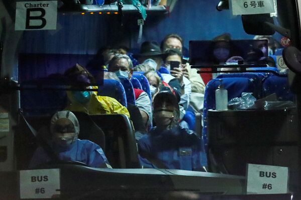 Люди в масках в автобусе, который перевозит пассажиров США, находившихся на борту круизного лайнера Diamond Princess, где произошла вспышка коронавируса. На снимке - автобус вывозит людей с пристани Дайкоку в Иокогаме, Япония, где в круизном терминале стоит лайнер - Sputnik Грузия