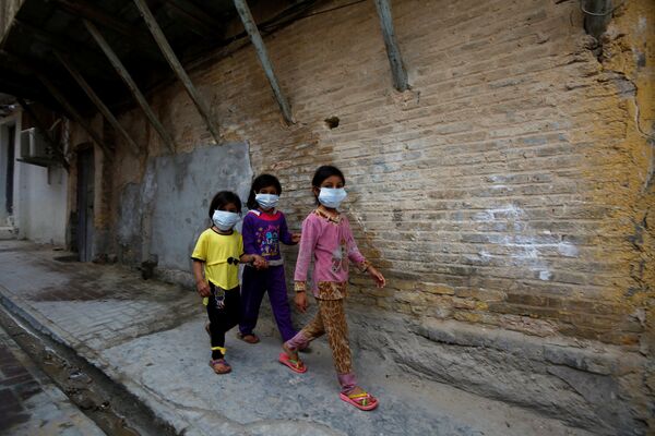 Случай коронавируса был зафиксирован и в Ираке, в городе Наджаф. На фото - иранские дети в масках идут по городской улице мимо религиозной школы - Sputnik Грузия