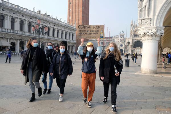 Группа девушек в защитных масках идет по площади Сан-Марко в Венеции с плакатом Корона-тур. Надо иметь смелость, даже чтобы бояться, после того, как последние дни Венецианского карнавала были отменены из-за вспышки коронавируса на севере Италии - Sputnik Грузия