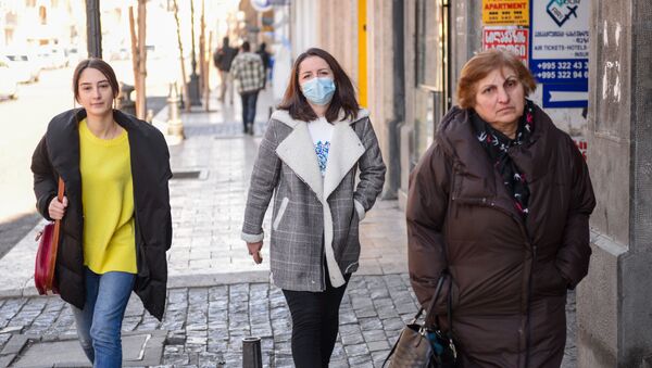 Жители столицы Грузии. Девушки идут по улице в масках, защищаясь от коронавируса - Sputnik Грузия