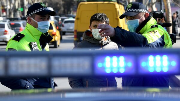 Полицейские в масках дежурят у инфекционной больницы. Люди в масках ждут вестей от близких - Sputnik Грузия