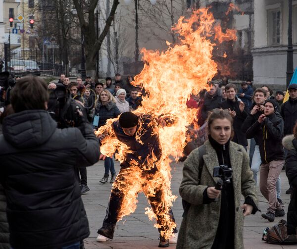 Во время акции протеста под стенами Офиса президента Украины против медицинской реформы мужчина сам себя поджег. Погасить горящую одежду сразу же бросились участники митинга - Sputnik Грузия