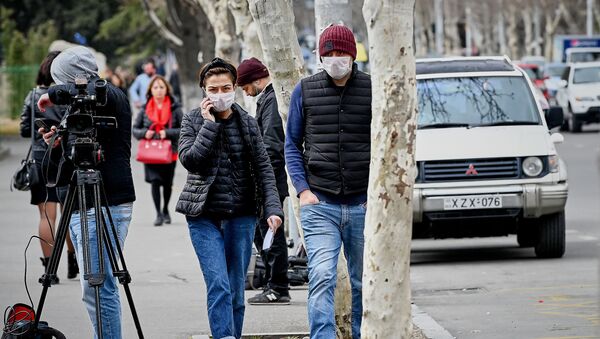 Люди идут по улице в масках у тбилисской инфекционной больницы - Sputnik Грузия