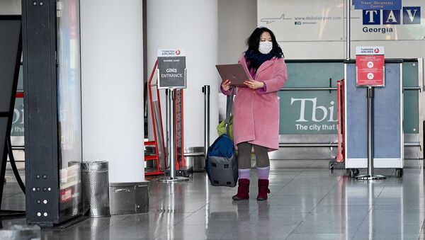 Китаянка в маске и с ноутбуком у стойки регистрации на авиарейсы в тбилисском аэропорту - Sputnik Грузия