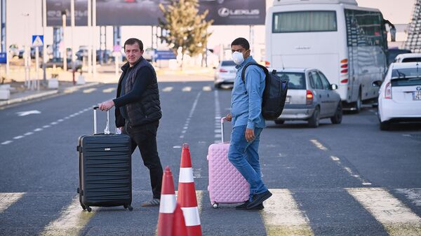Пассажиры в масках в тбилисском аэропорту после прибытия идут на стоянку - Sputnik Грузия