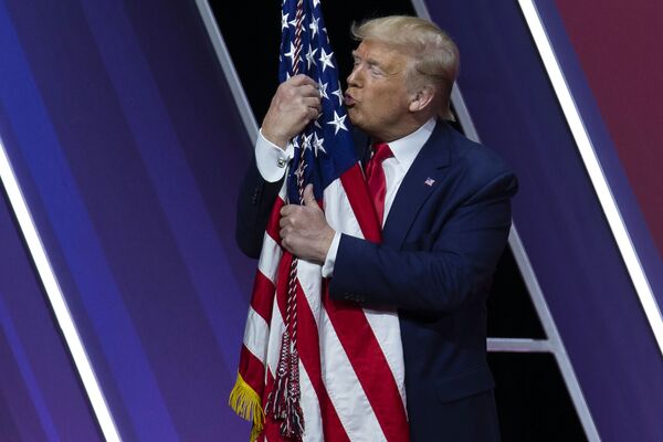Нежные объятия Трампа с американским флагом произошли на конференции Союза американских консерваторов - Sputnik Грузия