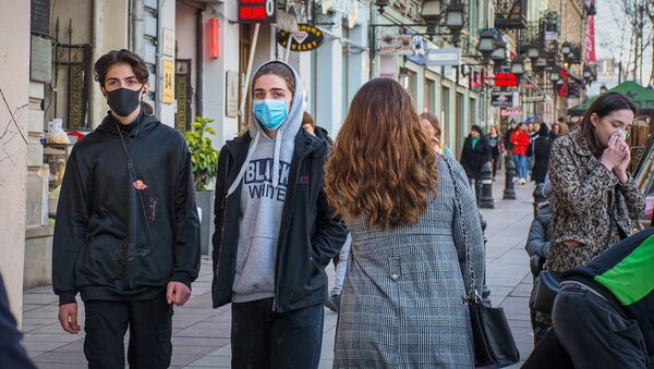 Молодые люди в масках идут по улице, защищаясь от коронавируса - Sputnik Грузия