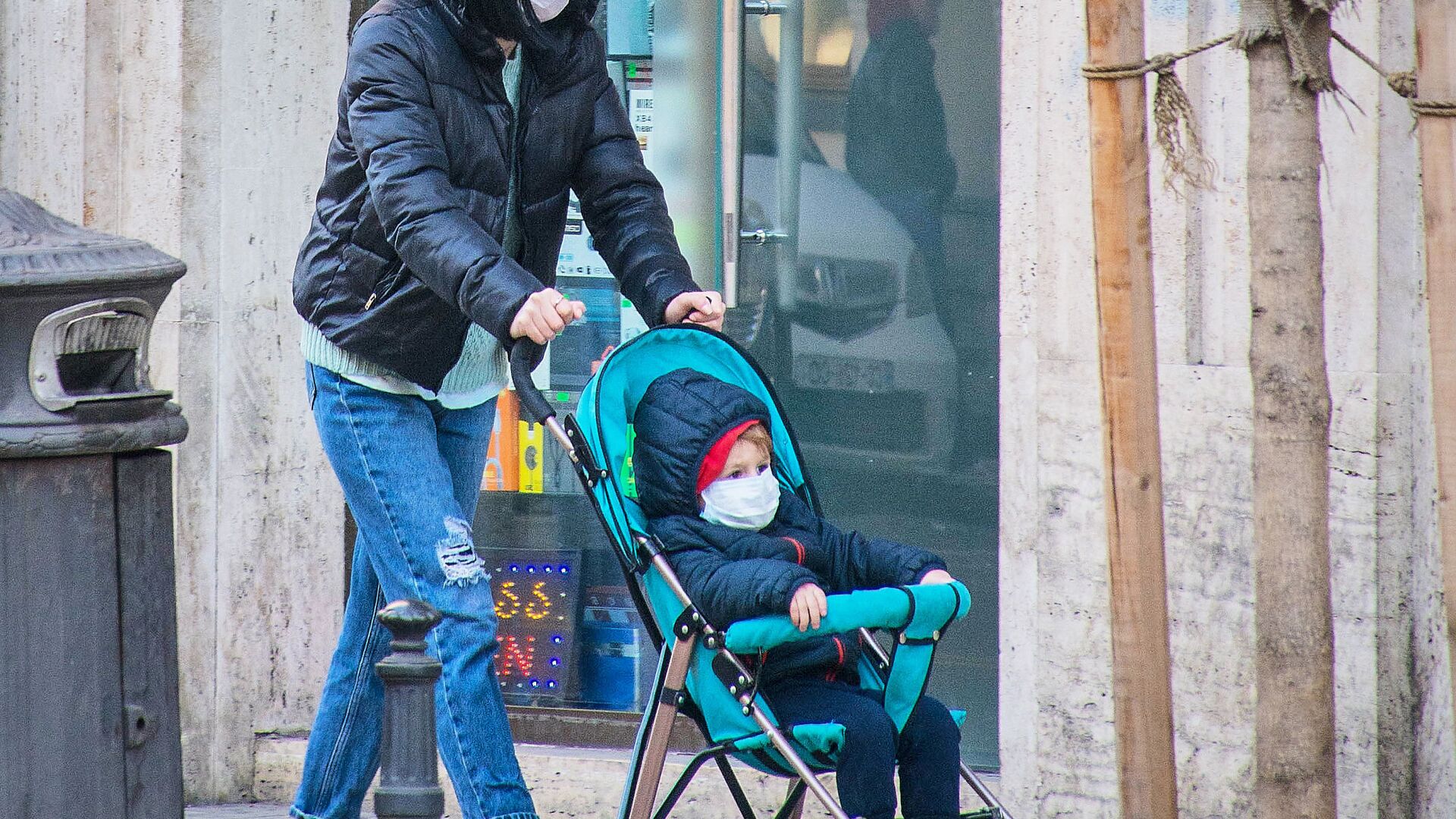 Девушка в маске идет с ребенком в коляске по улице защищаясь от коронавируса - Sputnik Грузия, 1920, 23.04.2022