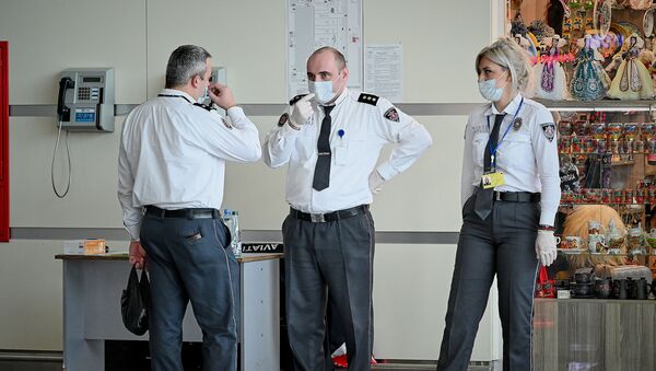 Сотрудники тбилисского аэропорта в защитных медицинских масках на стойке регистрации. Власти Грузии принимают меры против коронавируса - Sputnik Грузия