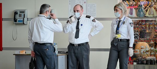 Сотрудники тбилисского аэропорта в защитных медицинских масках на стойке регистрации. Власти Грузии принимают меры против коронавируса - Sputnik Грузия