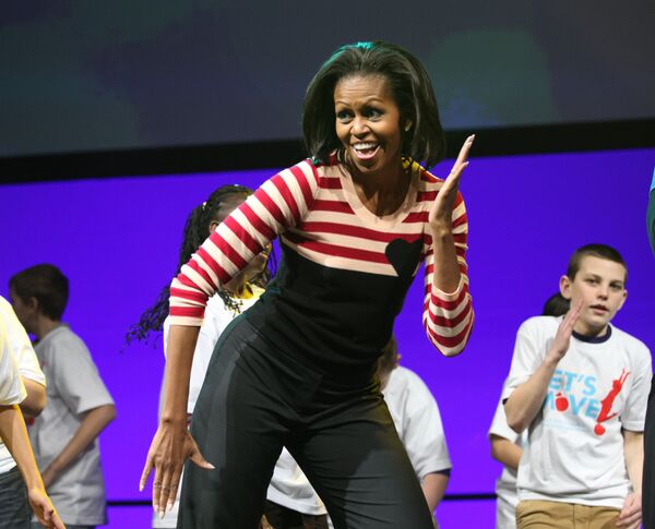 Первая леди Мишель Обама во время трехдневного тура по стране в 2012 году. Более десяти тысяч детей с шестого по девятый класс из школ штата Айова присоединились к ней во время интерактивного празднования Давайте двигаться на стадионе Wells Fargo Arena в Де-Мойне
 - Sputnik Грузия
