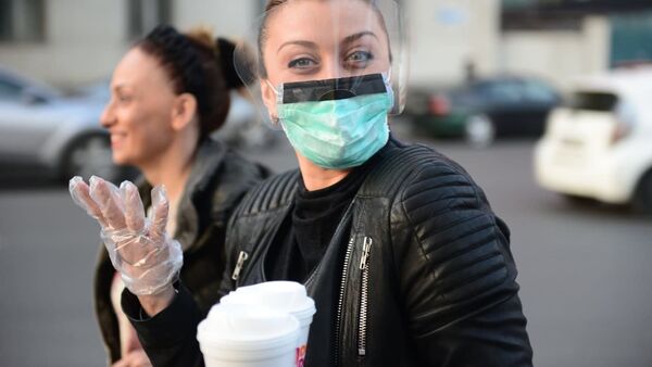 Женщина в медицинской защитной маске и перчатках во время мер по превенции коронавируса - Sputnik Грузия