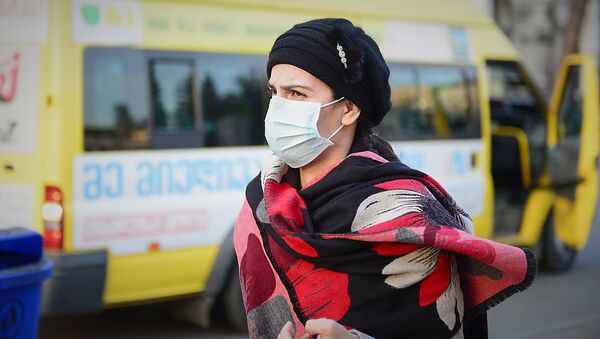 Люди в защитных медицинских масках на остановке во время мер по превенции коронавируса - Sputnik Грузия