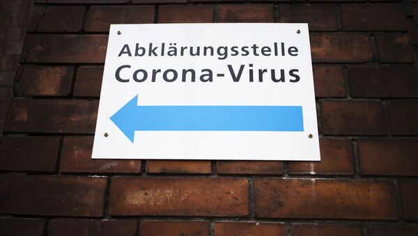 Указатель на стене госпиталя в Берлине, Германия, показывающий направление к центру по тестированию на коронавирус - Sputnik Грузия