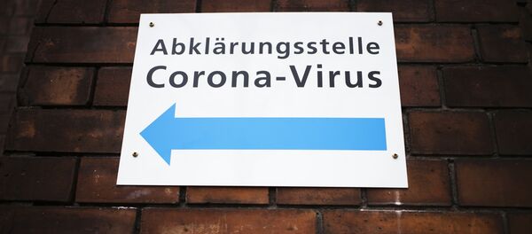 Указатель на стене госпиталя в Берлине, Германия, показывающий направление к центру по тестированию на коронавирус - Sputnik Грузия