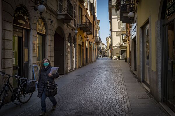 Женщина в маске на одной из улиц Новары в Италии - Sputnik Грузия