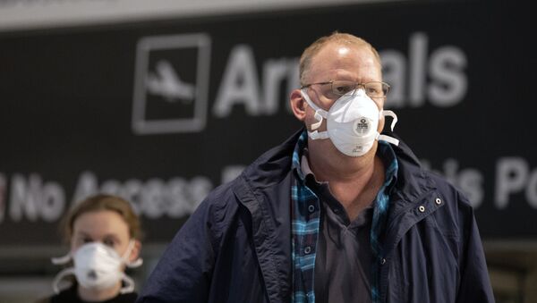 Пассажиры из Европы в медицинских масках после прибытия в аэропорт готовятся пройти досмотр в Бостоне, США - Sputnik Грузия