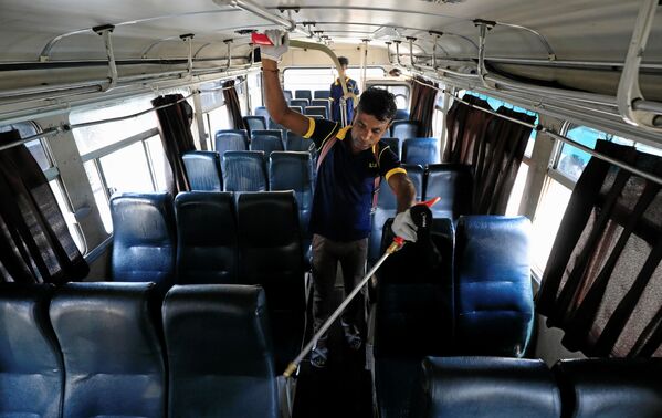 На Шри-Ланке подтверждено 28 случаев коронавируса. Власти решили провести дезинфекцию людных мест и общественного транспорта. На фото - рабочий без спецодежды и защитных средств проводит дезинфекцию внутри одного из автобусов в городе Коломбо - Sputnik Грузия