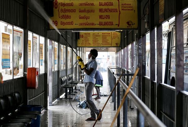 Рабочий проводит дезинфекцию на автобусной станции в Коломбо, Шри Ланка. Сотрудники рискуют - у них нет какой-либо защитной спецодежды, кроме перчаток - Sputnik Грузия
