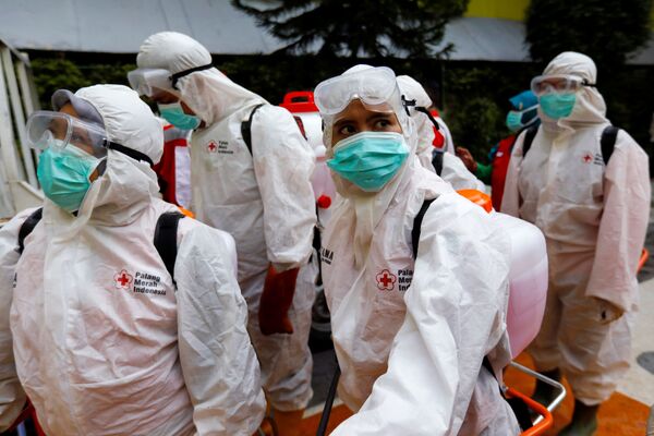 Волонтеры из Индонезийского Красного Креста в защитных костюмах перед проведением дезинфекции в Джакарте - Sputnik Грузия