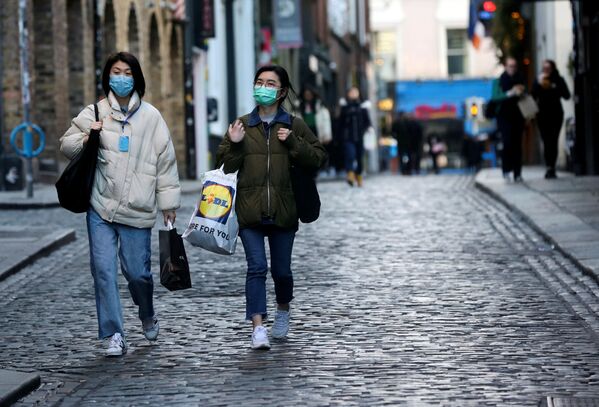 Туристы в масках гуляют по Дублину в районе Темпл-Бар. В Ирландии все бары, рестораны и развлекательные заведения добровольно закрываются, чтобы снизить темпы распространения коронавируса - Sputnik Грузия