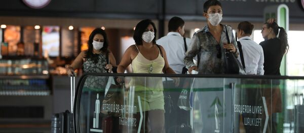 Пассажиры в защитных масках из-за страха перед коронавирусом в аэропорту перед посадкой в самолет - Sputnik Грузия