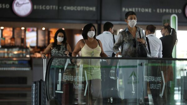 Пассажиры в защитных масках из-за страха перед коронавирусом в аэропорту перед посадкой в самолет - Sputnik Грузия