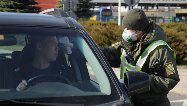 Украинский пограничник меряет температуру у водителя на КПП на границе с Польшей - Sputnik Грузия
