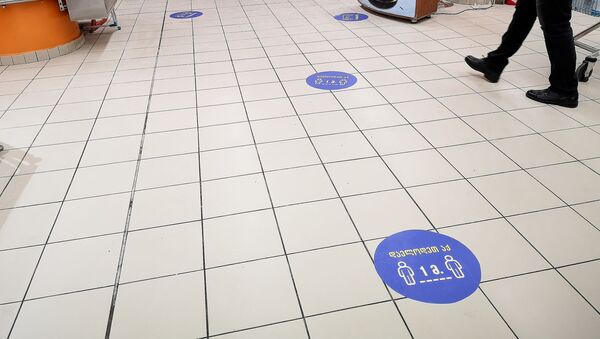 Наклейки на полу в супермаркете, призывающие покупателей выдерживать дистанцию друг от друга в полтора метра. В Грузии борются с коронавирусом - Sputnik Грузия