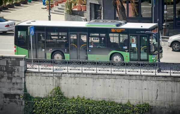 Почти пустой автобус едет днем по центру Тбилиси. В столице страны власти запретили движение маршрутных такси, которые не проходили регулярной дезинфекции. Как видно по этому фото, люди стараются уже лишний раз не пользоваться общественным транспортом. В автобусах и метро дезинфекция проводится теперь каждый день - Sputnik Грузия