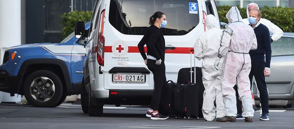 Врачи в защитных костюмах и масках в Генуе, Италия, сопровождают пассажиров, эвакуированных с борта лайнера Costa Luminosa, на борту которого была вспышка коронавируса - Sputnik Грузия