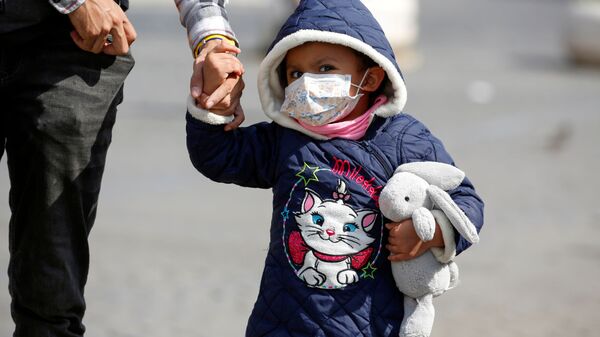 Ребенок в маске идет с родителями по Риму, Италия. Вся страна парализована из-за эпидемии коронавируса - Sputnik Грузия