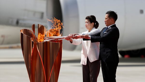 Трехкратные олимпийские золотые медалисты Тадаиро Номура и Саори Йошида на церемонии передачи Японии олимпийского огня - Sputnik Грузия
