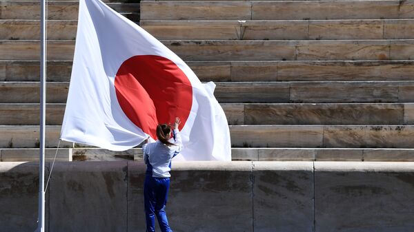 Спортсмен на фоне флага Японии на церемонии передачи Японии огня летних Олимпийских игр, Афины - Sputnik Грузия