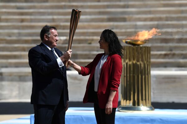 Президент Национального олимпийского комитета Греции Спирос Капралос передал огонь представителю оргкомитета Игр-2020 Наоко Имото, бывшей пловчихе, участнице Олимпийских игр 1996 года в Атланте - Sputnik Грузия